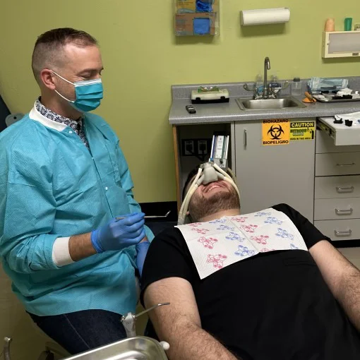 Dr. Kevin Osborne smiling while treating a patient wearing a nitrous oxide mask